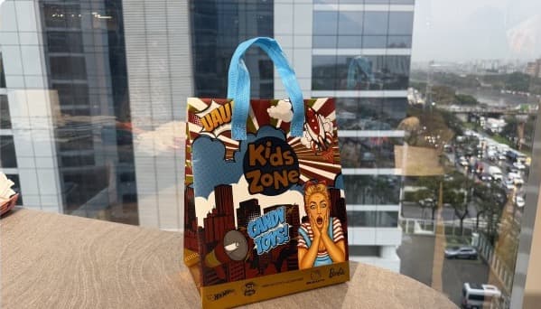 Sacola personalizada da Kids Zone sobre uma mesa diante de uma janela.
